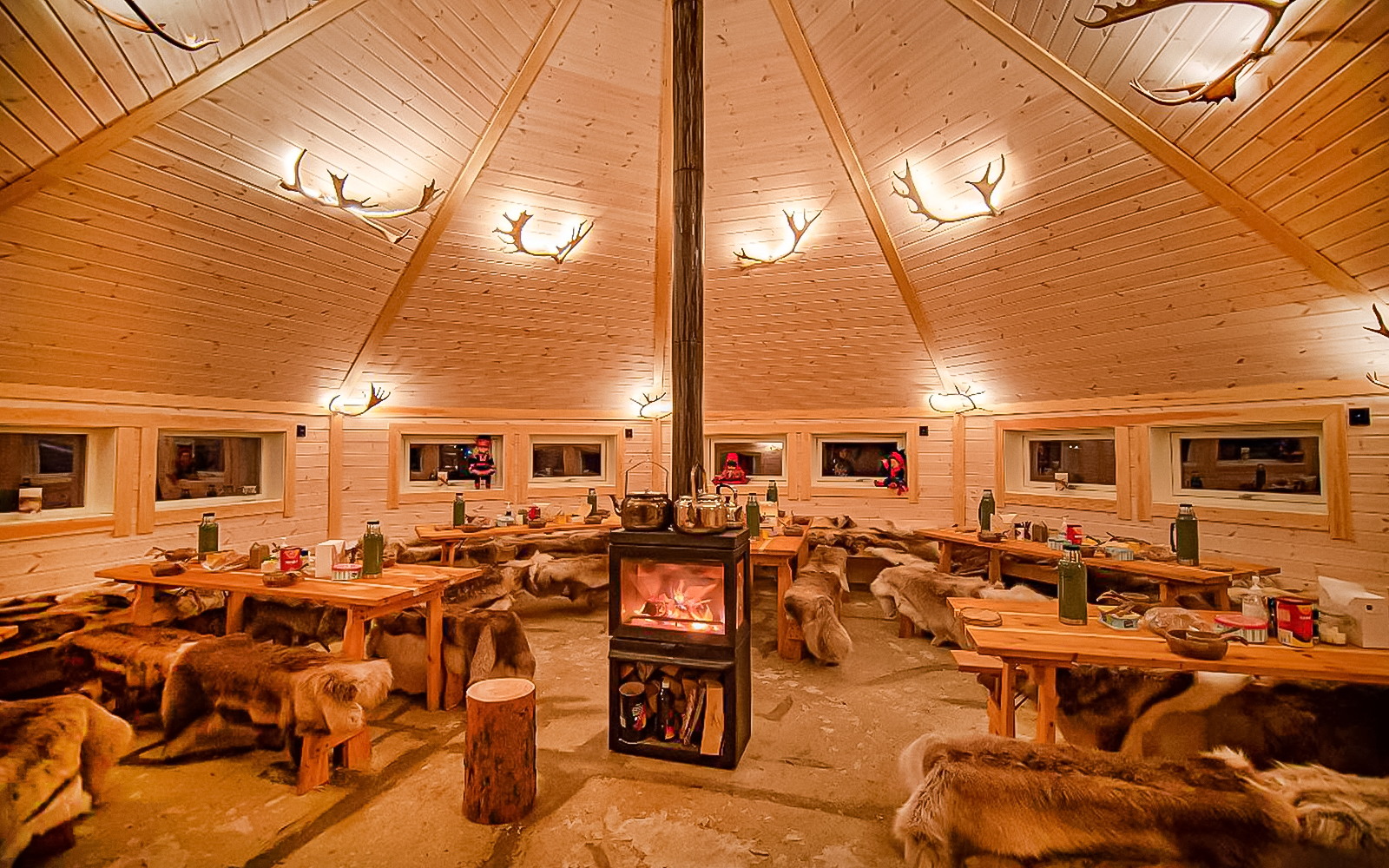 Cozy wooden cabin interior with fireplace, Tromso reindeer sledding tour.