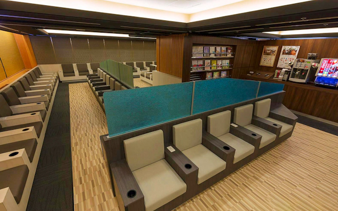 Waiting area seating at Narita International Airport Terminal 1 lounge with refreshments.