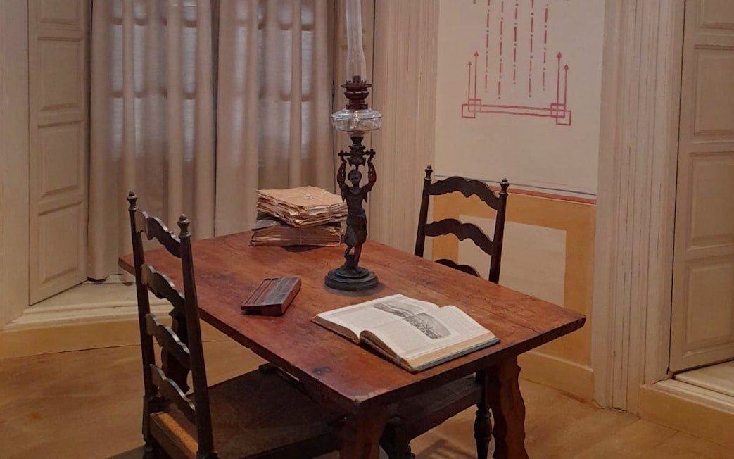 Picasso's birthplace museum interior with table, lamp, and open book in Malaga.