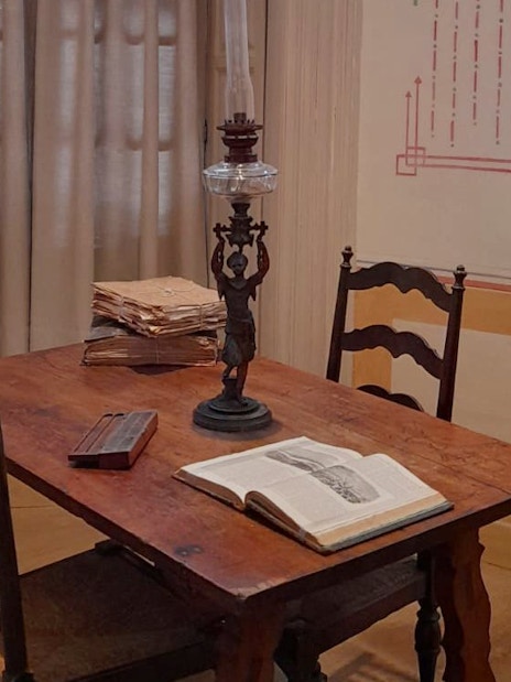 Picasso's birthplace museum interior with table, lamp, and open book in Malaga.
