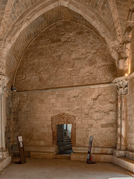 Interiors of Castel del Monte in Andria, featuring stone arches and columns.