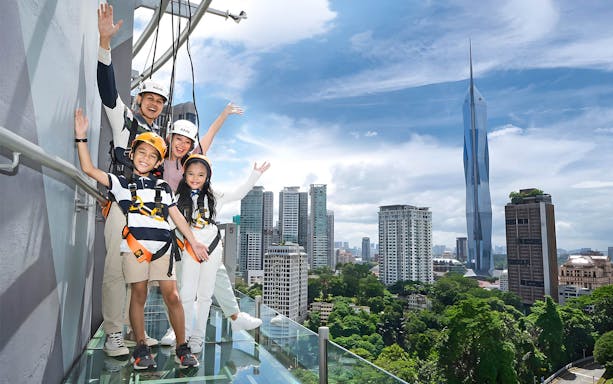 Family enjoying the view from KL Tower Sky Deck with city skyline in the background.