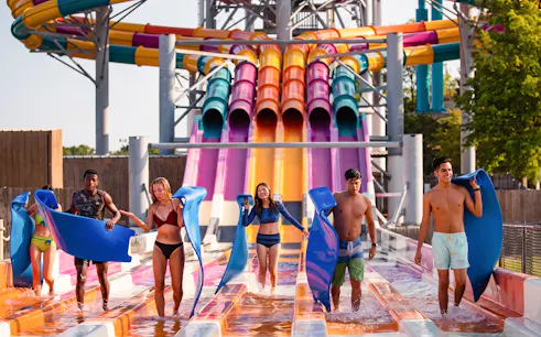 Visitors with mats at Wahoo Racer water slide, Hurricane Harbor Arlington.