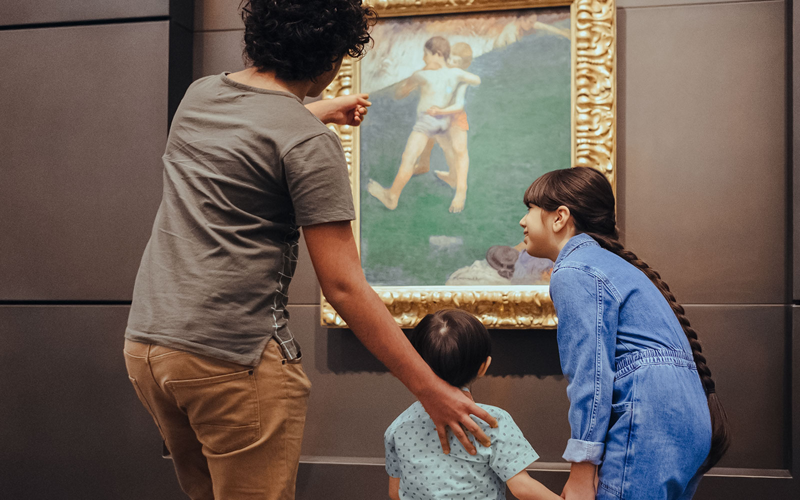 Visitors admiring a painting at Louvre Museum Abu Dhabi exhibit.