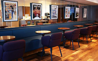 Primeclass Lounge seating area with framed artwork at JFK Airport, New York.