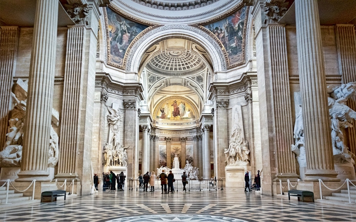 Interior of the Paris Pantheon with ornate columns and detailed sculptures.