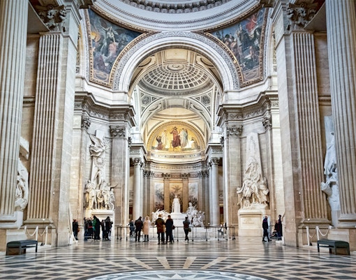 Visitors exploring the interior of the Paris Pantheon, admiring its grand architecture.