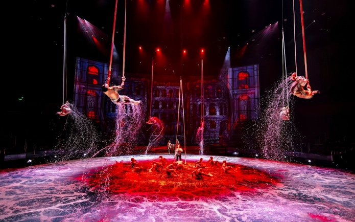 Performers executing rope tricks over water at House of Dancing Water Show.