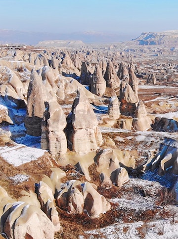 Fairy chimneys in Goreme Valley, Cappadocia, with snow-dusted rock formations.