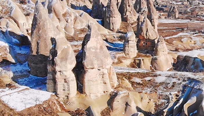 Fairy chimneys in Goreme Valley, Cappadocia, with snow-dusted rock formations.