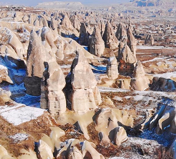 Fairy chimneys in Goreme Valley, Cappadocia, with snow-dusted rock formations.