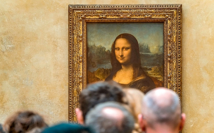 Tourists viewing the Mona Lisa at the Louvre Museum, Paris with reserved access.