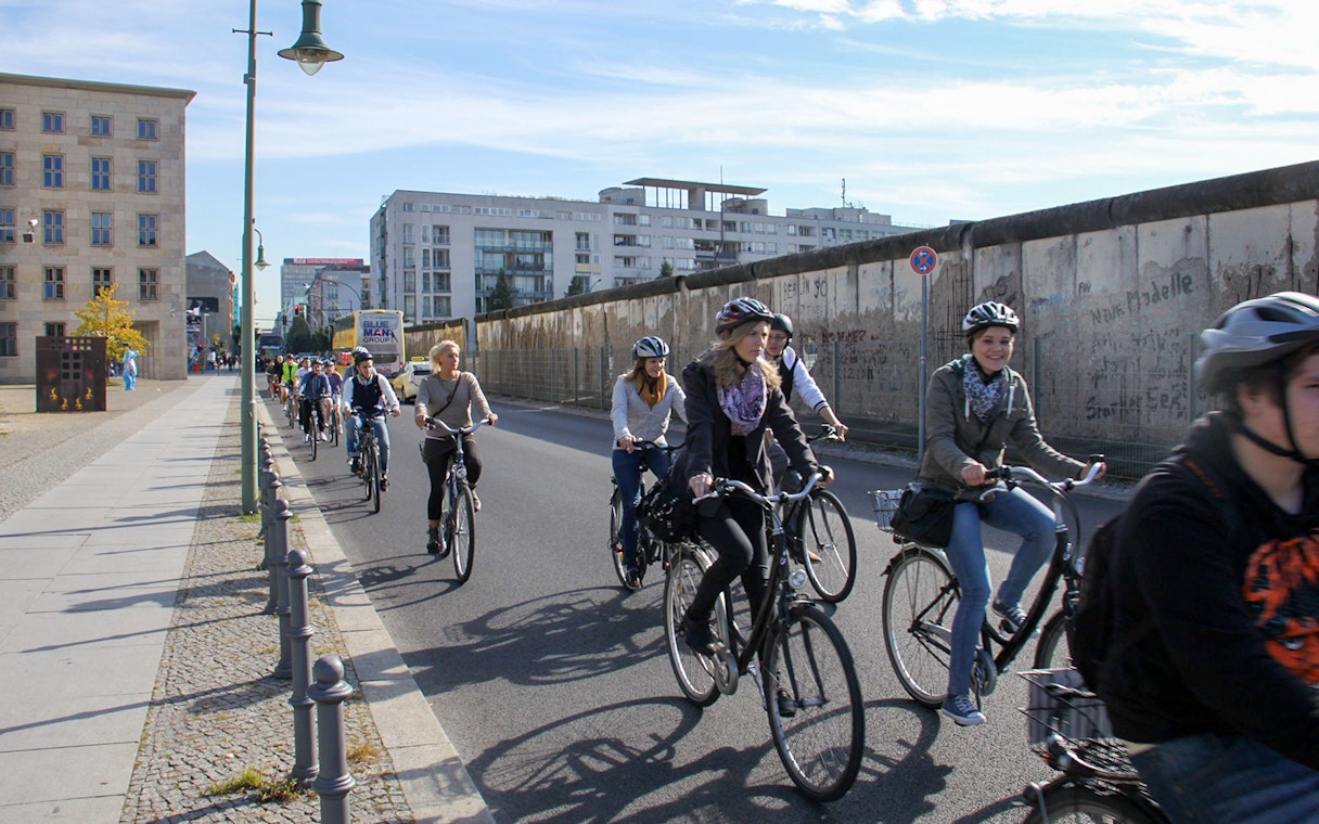 Cyclists on a guided tour along the Berlin Wall, exploring Third Reich history.