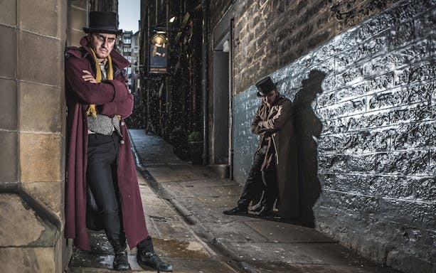 Victorian-costumed actors in a dim Edinburgh alley for the Dungeon Tour.