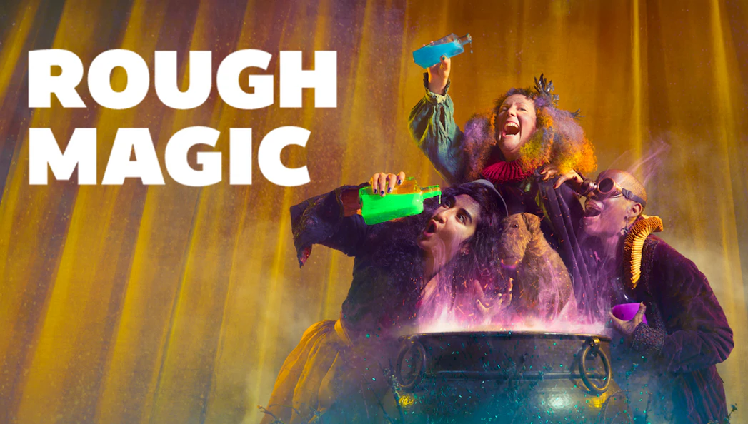 Three performers with colorful costumes and potions around a cauldron, "Rough Magic" text.