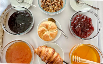 Breakfast buffet with croissant, bread roll, jams, honey, and nuts on Sunshine Booze Cruise, Budapest.
