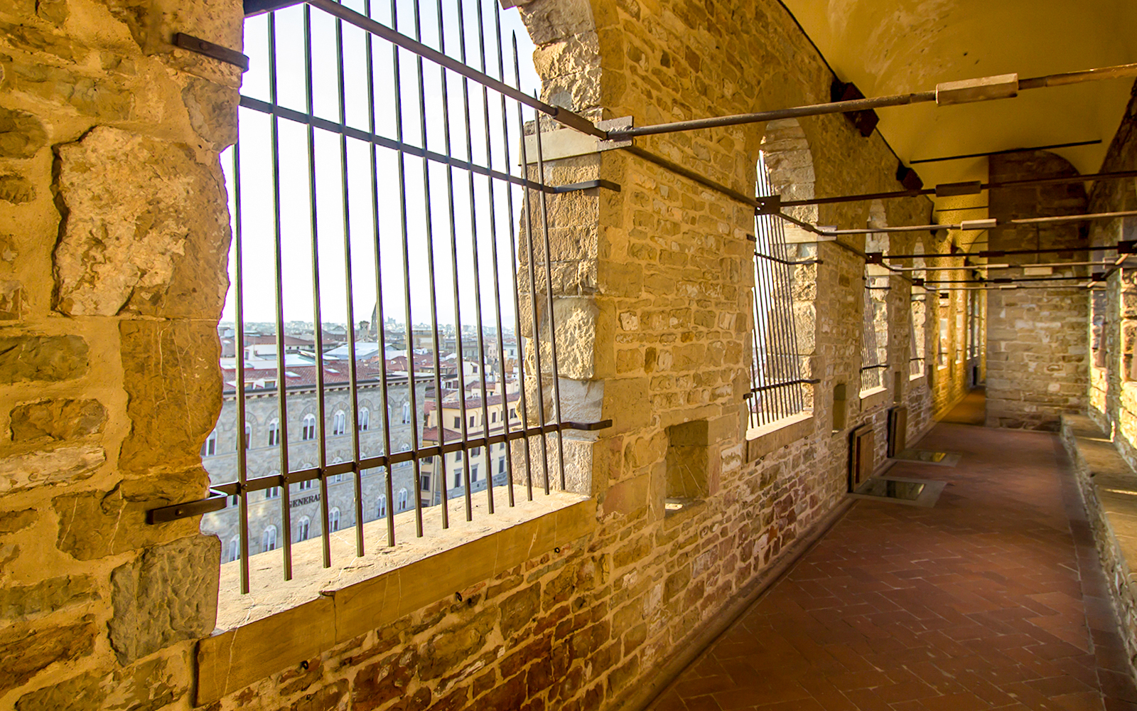 Long corridor with stone walls leading to the tower of Palazzo Vecchio, Florence, Tuscany.