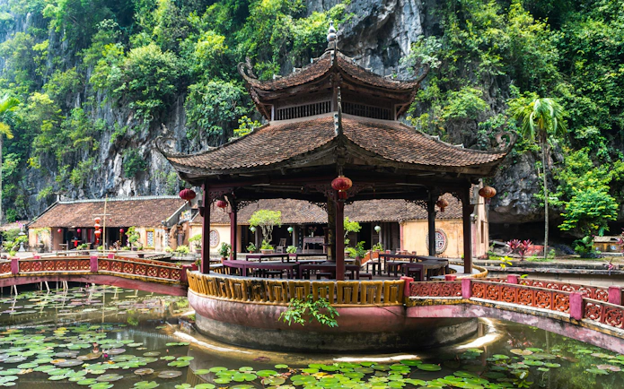 Pagoda surrounded by water lilies at Hoa Lu Ancient Capital, Ninh Binh, Vietnam.