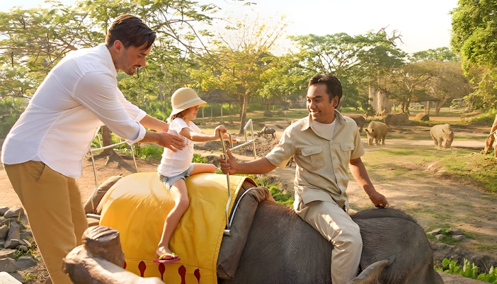 Family on elephant ride with guide at Safari World, Bangkok, Thailand.