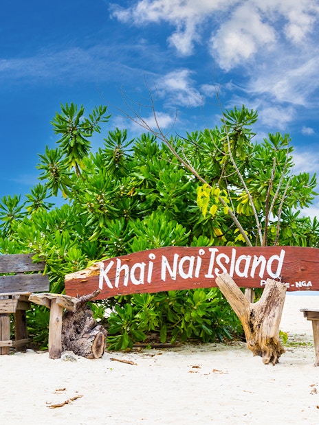 Khai Nai Island sign on sandy beach with tropical plants, part of Phuket 3 Khai Island tour.