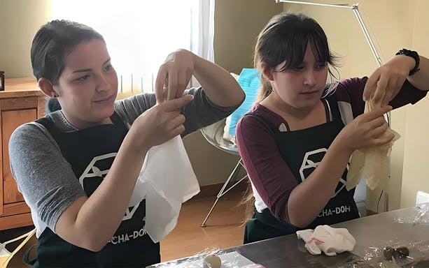 Participants crafting wagashi in a Tokyo class with tea.