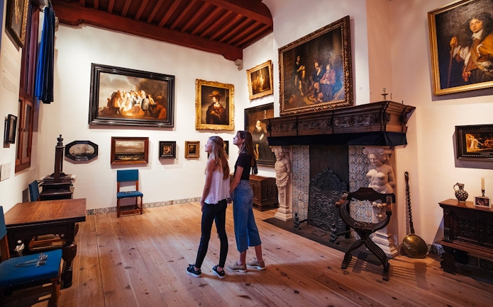 Guests exploring art in Rembrandt House Museum during a multimedia tour.
