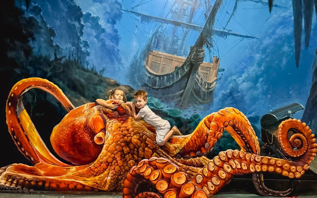 Children interacting with giant octopus art at ArtVo Melbourne Trick-Art Gallery.