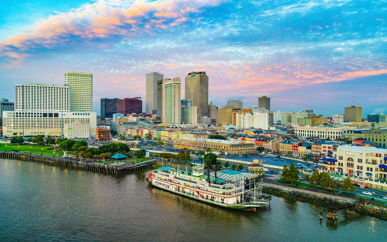 New Orleans skyline with riverboat on Mississippi River at sunset.