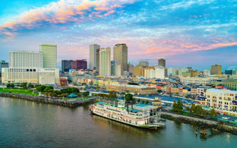 New Orleans skyline with riverboat on Mississippi River at sunset.
