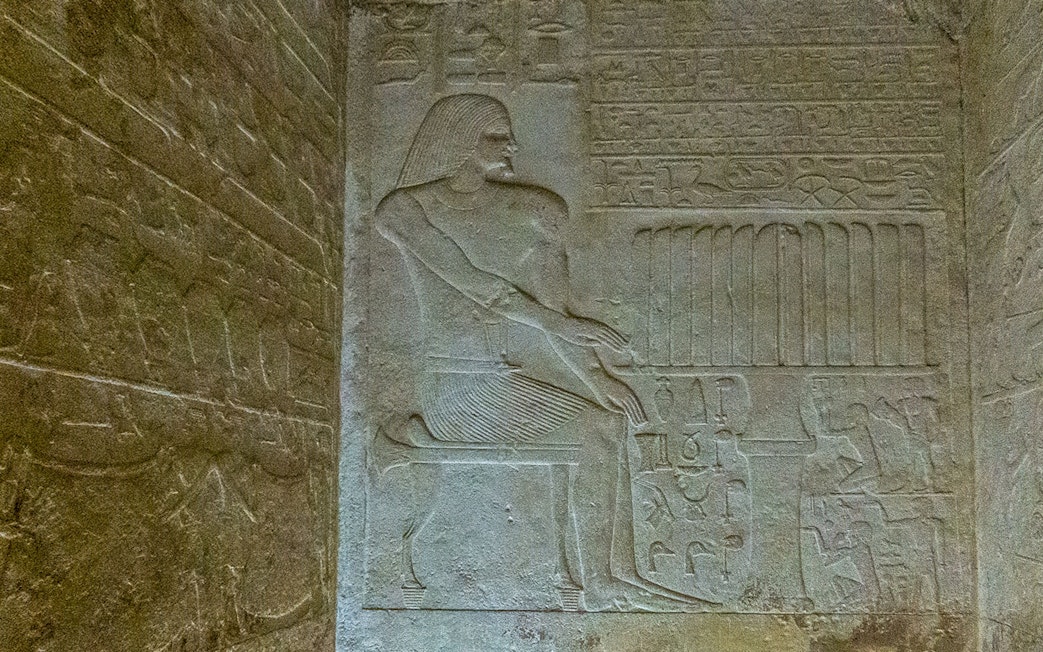 Bas relief depicting a seated figure with hieroglyphs in the Pyramid of Queen Meritetis I, Giza Necropolis, Cairo.