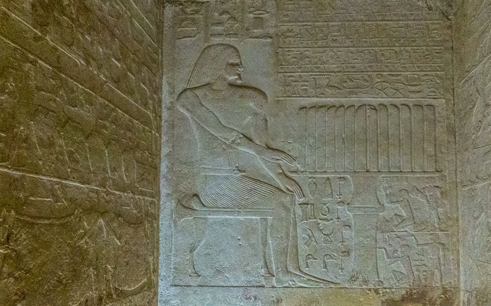 Bas relief depicting a seated figure with hieroglyphs in the Pyramid of Queen Meritetis I, Giza Necropolis, Cairo.