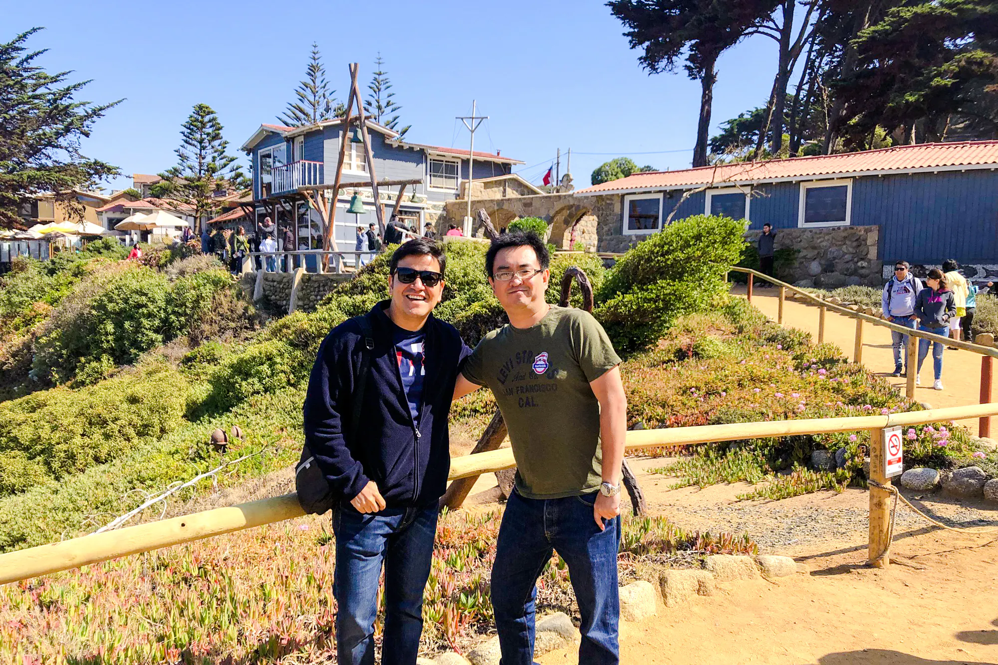 Visitors at Isla Negra with Pablo Neruda's house in the background, part of the Santiago day tour.