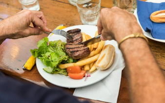 Steak and salad meal with fries on a wooden table during Great Barrier Reef tour.