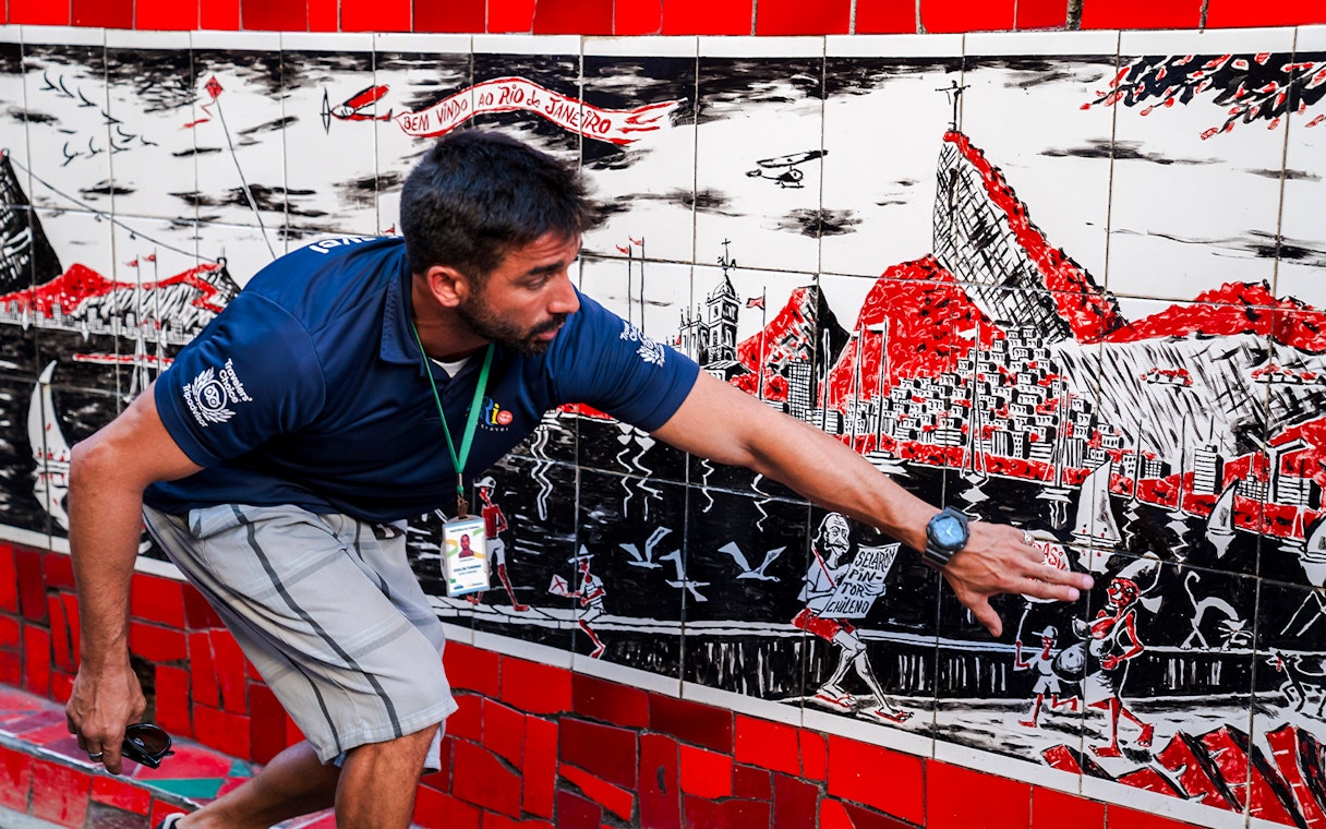 Tour guide explaining artwork on Selarón Steps in Rio de Janeiro.