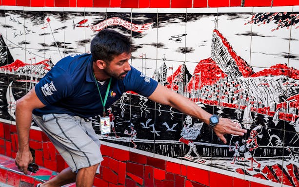 Tour guide explaining artwork on Selarón Steps in Rio de Janeiro.