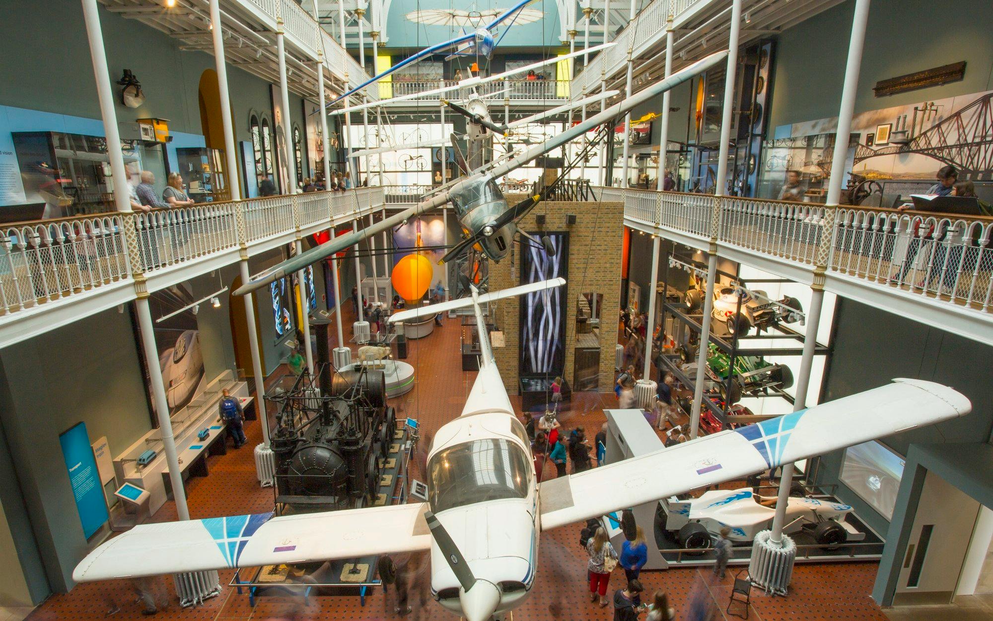 Aircraft and exhibits displayed in a museum gallery, showcasing aviation history.