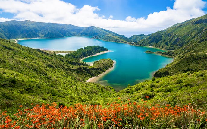 Lagoa do Fogo view with lush green hills and vibrant blue water, Azores.