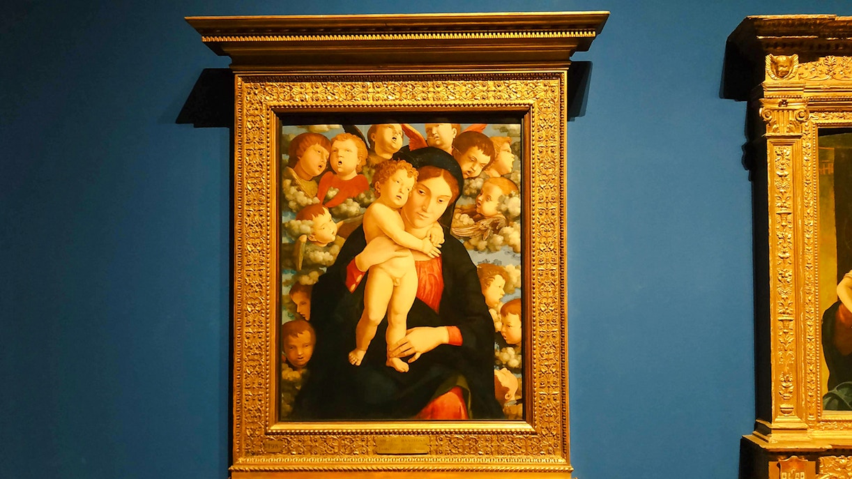 Wall display of paintings at Pinacoteca di Brera, Milan, featuring the Madonna of Cherubim.