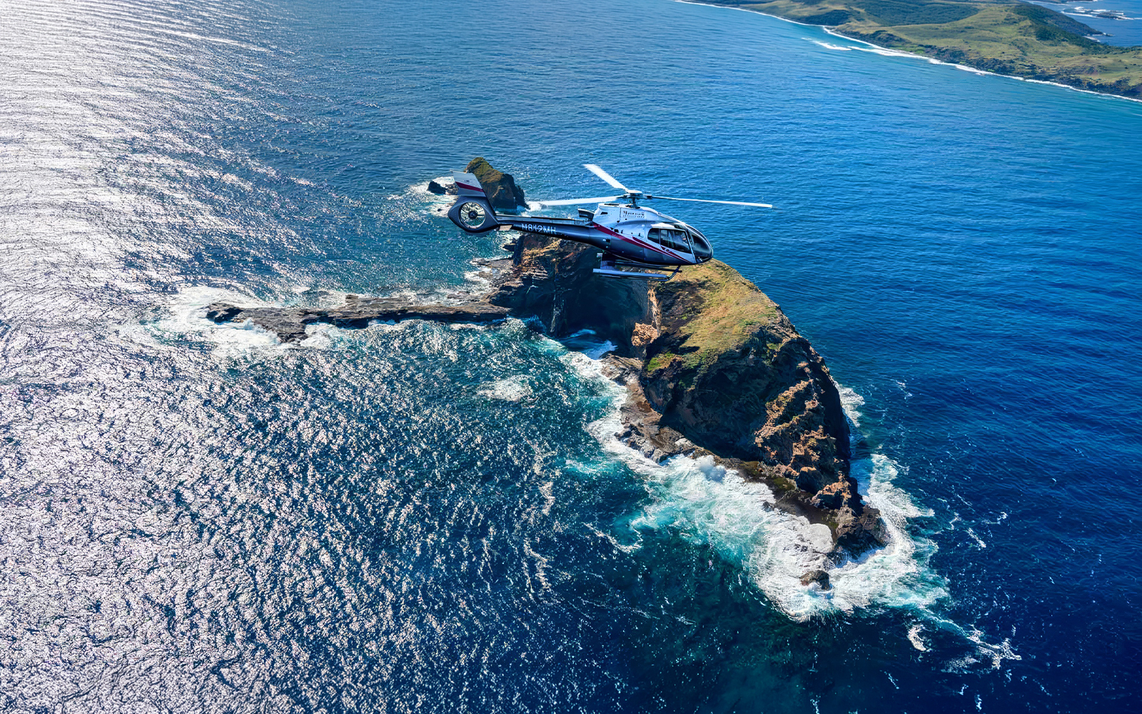 Helicopter flying over ocean and cliffs in Maui, Hawaii during tour.