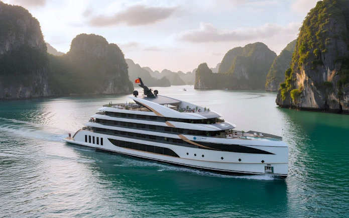 Luxury cruise ship sailing through Ha Long Bay with limestone karsts in the background.