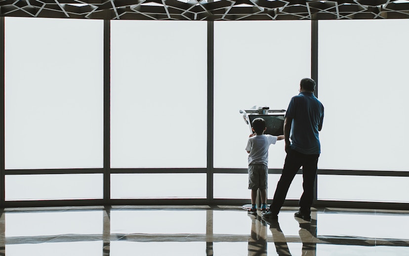 Child and adult using a telescope at Burj Khalifa observation deck, Dubai.