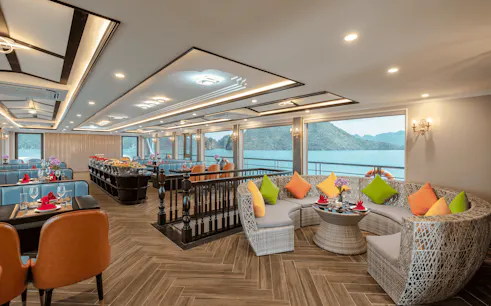 Luxurious dining area on Amethyst Cruise with Halong Bay view, featuring elegant seating and decor.