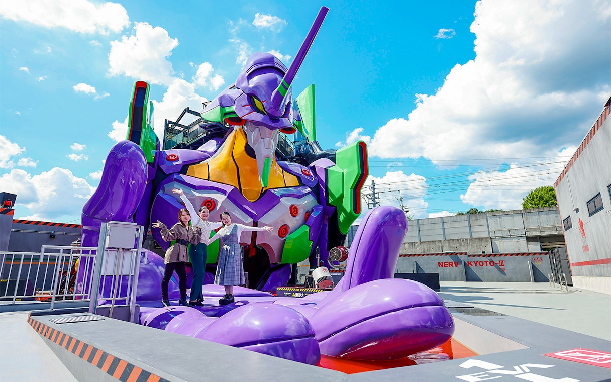 Visitors posing with a giant robot statue at TOEI Kyoto Studio Park.
