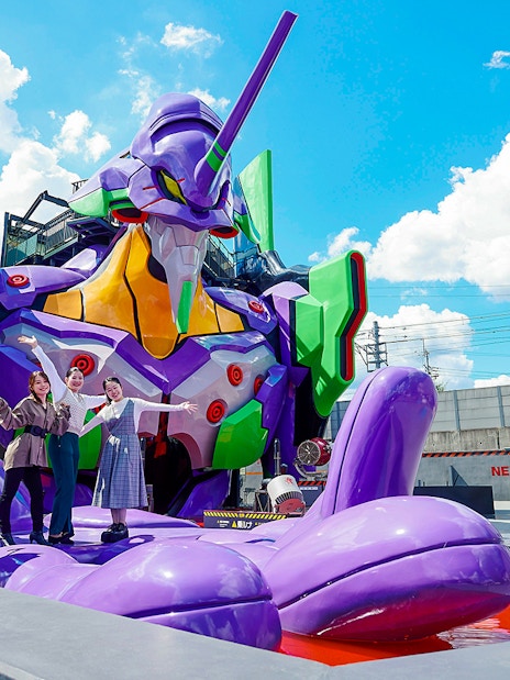 Visitors posing with a giant robot statue at TOEI Kyoto Studio Park.