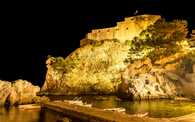 St. Lawrence Fortress illuminated at night, viewed from a dinner cruise in Dubrovnik.