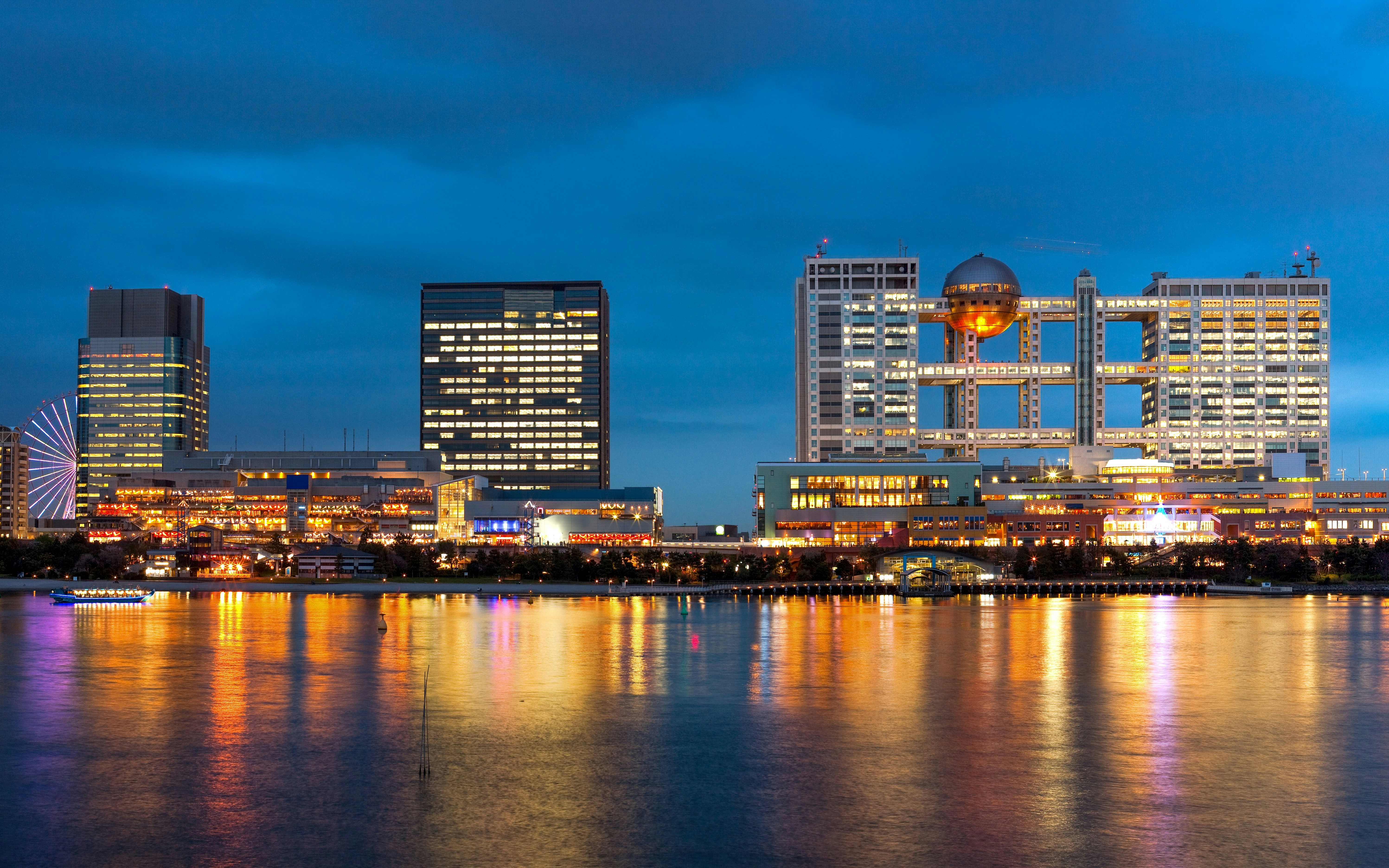 Skyline of Odaiba artificial island at night with illuminated buildings, Tokyo, Japan.