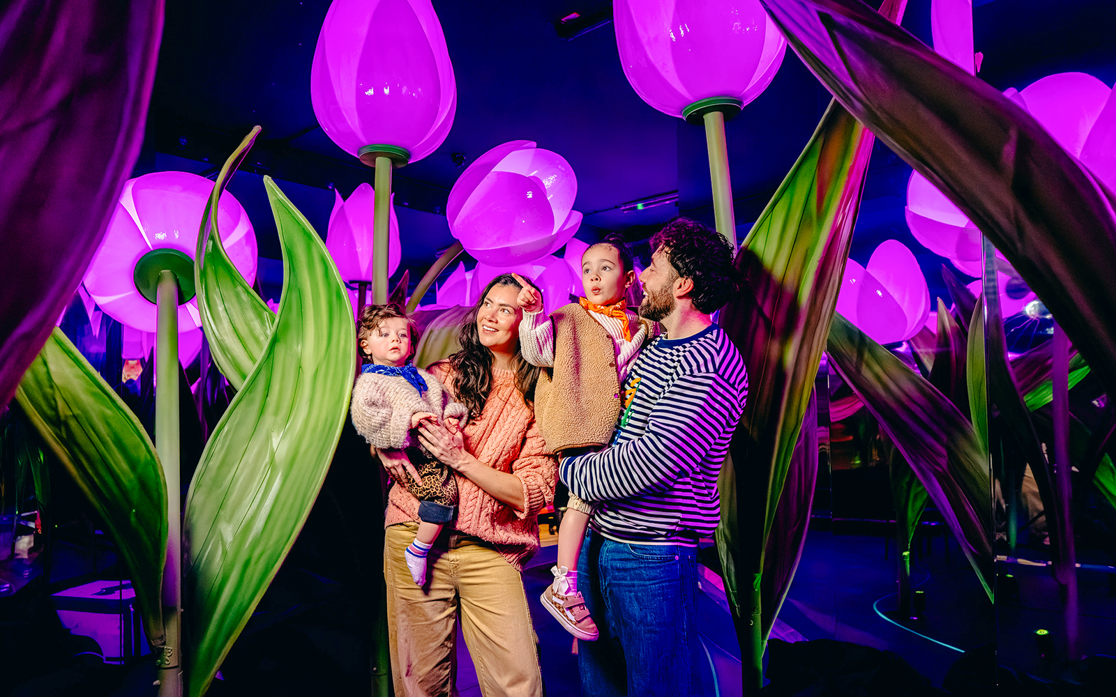 Guests exploring illuminated tulip exhibit in Holland experience.