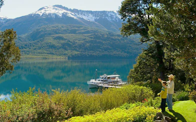 Scenic viewpoint of Lake Nahuel Huapi with boat docked, surrounded by Patagonian landscape on Victoria Island.