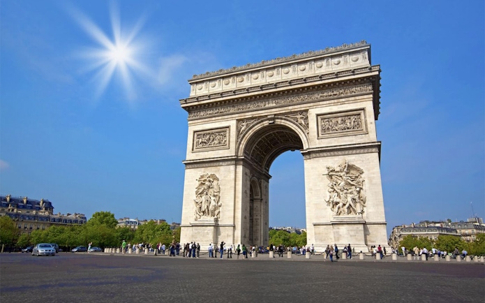 Arc de Triomphe in Paris on a sunny day, part of a day trip with Eiffel Tower lunch.
