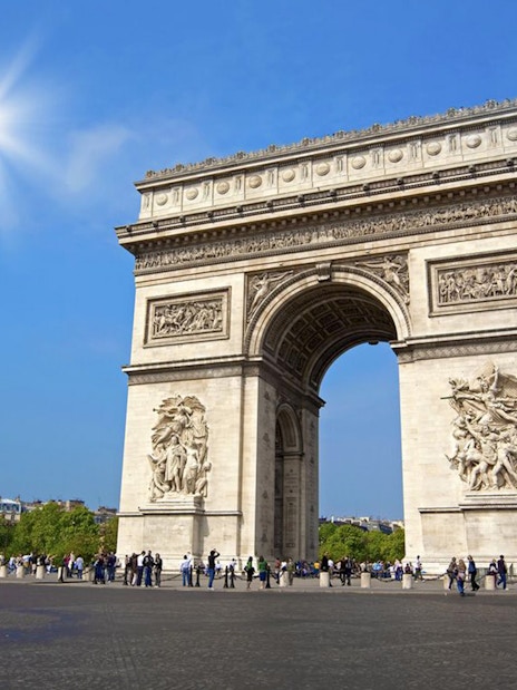 Arc de Triomphe in Paris on a sunny day, part of a day trip with Eiffel Tower lunch.